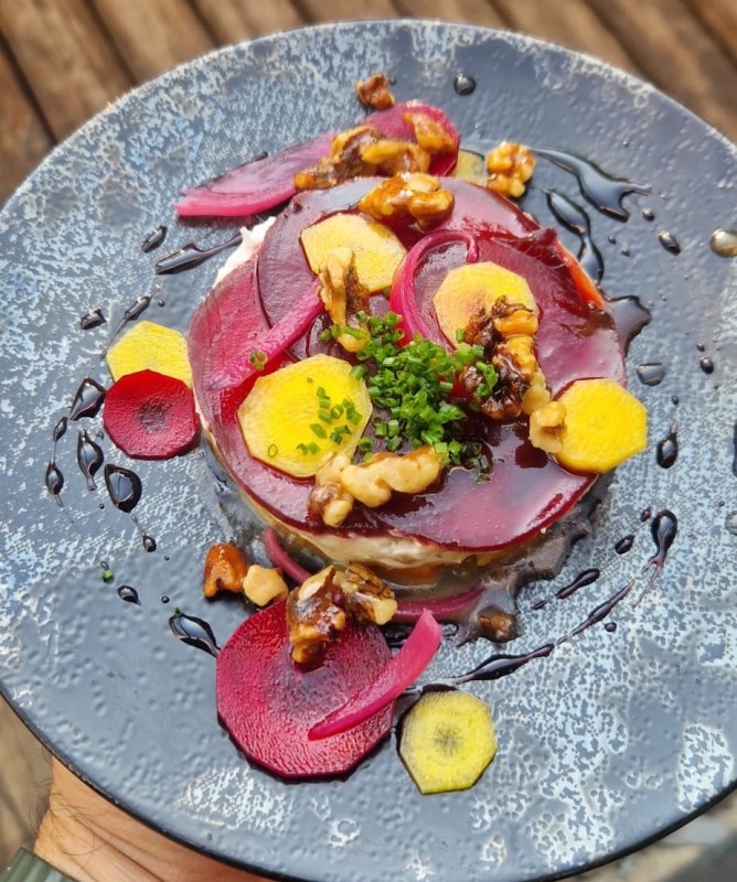 Pressé de légumes grillés, fromage de chèvre et noix torréfiées, sauce acidulée